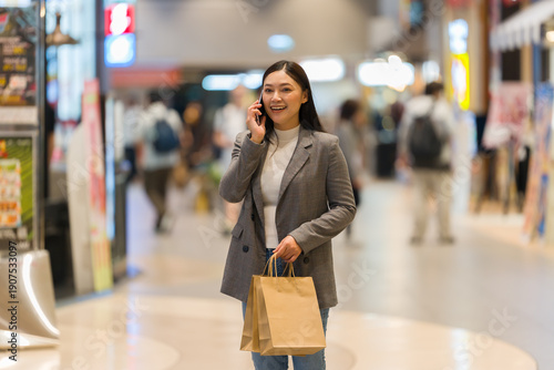 woman talking on mobile phone while shopping in shopping mall