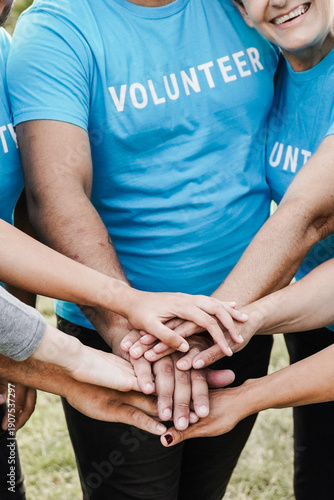 Happy group of volunteer people stacking hands celebrate together - Teamwork and charity support concept