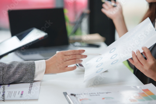 Tableau sur toile Close-up shot of two business professionals' hands pointing and analyzing financ
