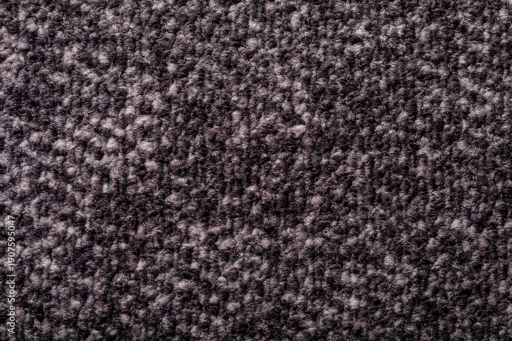 Fototapeta premium Close-up of a dark textured carpet. Perfect for backgrounds or interior design projects. Offers comfort, warmth and a se