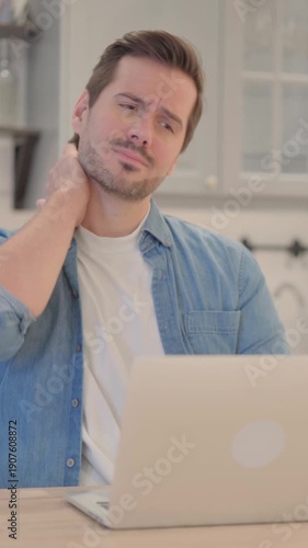 Young Man with Neck Pain Working on Laptop