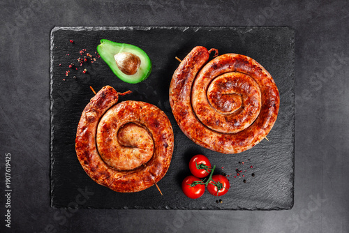 Grilled spiral sausages on black slate