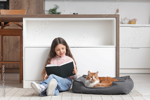 Cute little girl reading bo...