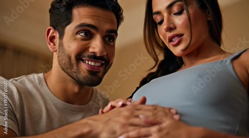 Expectant couple standing in a cozy living room