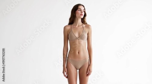 A woman in beige lingerie standing with arms outstretched