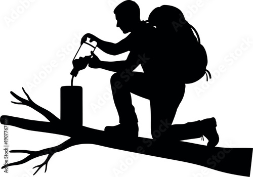 Silhouette of Backpacker Filtering Water Outdoors on Tree Branch for Wilderness Survival Concept
