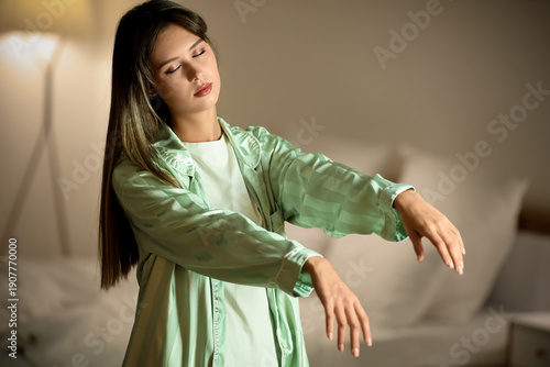 Female sleepwalker near bed in evening at home