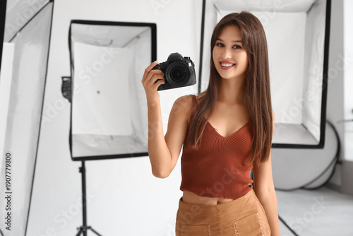 Beautiful photographer with camera during courses in studio