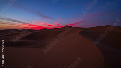 Timelapse of sunset over desert sand dunes with dramatic clouds