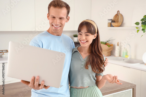 Young couple using laptop i...
