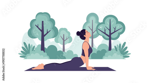 Athletic woman performing the cobra yoga pose on a mat outdoors in a green forest with tall trees and bushes.