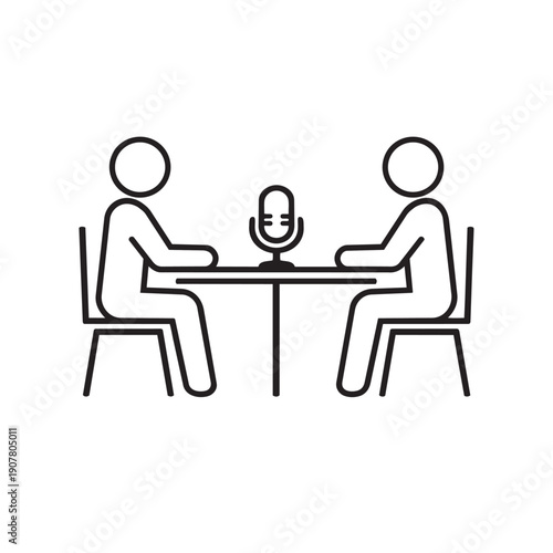 Two people sitting across from each other at a table with a microphone for an interview or discussion