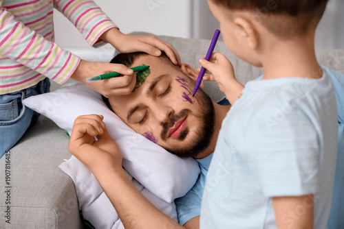 Картината върху платно Little children painting their father's face while he sleeping at home