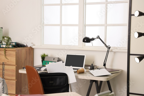 Messy workplace with laptop...