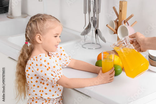 Mother pouring orange juice...