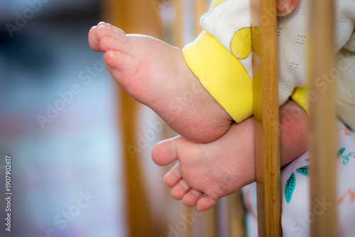 the baby's small baby legs sticking out of the crib. taken in close-up