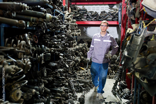 Photos Worker walks through a car parts junkyard in the factory