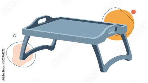 Sturdy grey plastic bed tray with foldable legs and handles on the sides shown against a white background with abstract orange shapes.