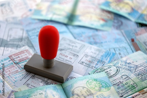 Border crossing stamp on big amount of passport pages full of colorful stamps after travel and tourism. Border control concept. Immigration and travel around the world