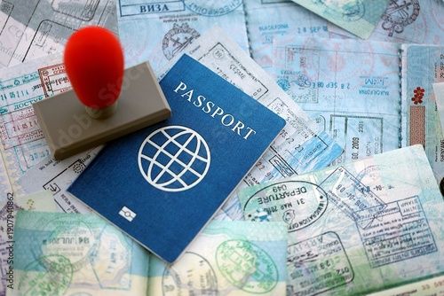 Border crossing stamp on passport pages full of colorful stamps after travel and tourism. Border control concept. Immigration and travel around the world