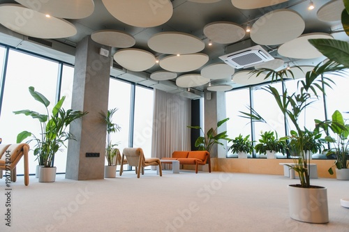 Obraz na płótnie Modern lounge area with comfortable seating and green plants