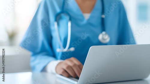 Medical professional in scrubs working on laptop, symbolizing digital healthcare, electronic records, telemedicine, and modern clinical workflow.