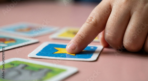 child's finger pointing at a flashcard with a yellow star, educational game and cognitive development