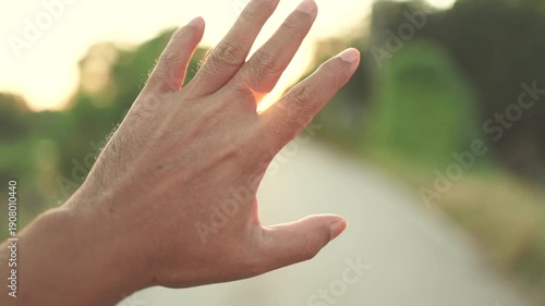 Hand reaching toward warm sunset light on a rural path, Hope concept, A hand reaching the glowing sunset, creating a warm, dreamy atmosphere with soft focus and natural light