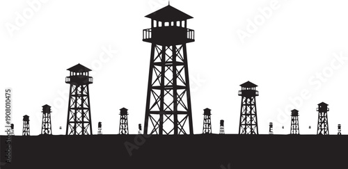 Silhouette of watchtowers and barbed wire fence at night