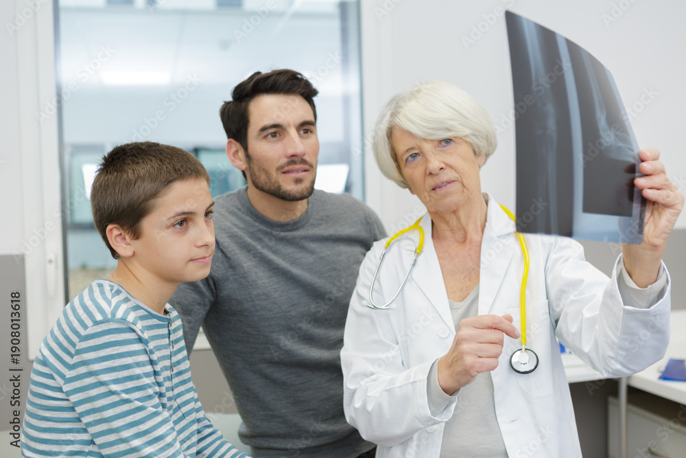 © auremar - attractive doctor showing an xray to his patient © auremar - attractive doctor showing an xray to his patient