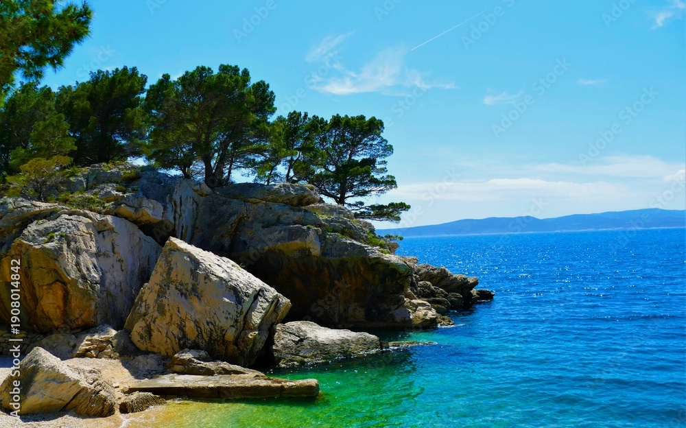 Fototapeta premium Peaceful lagoon with turquoise, clear sea, big rocks and green pine trees, Croatia