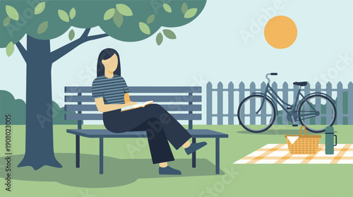 Woman reading a book on a park bench with a bicycle and picnic nearby