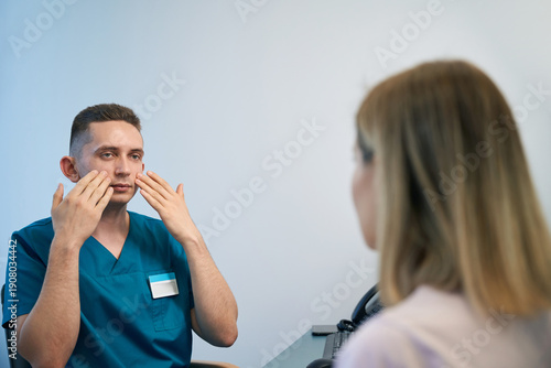 Otolaryngologist consulting female patient at modern ENT clinic