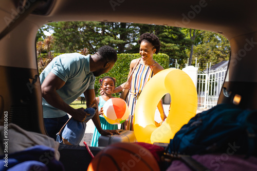 African american family putting all the luggage in the back of the car