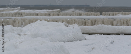 FROSTY WINTER ON THE SEA COAST - Icy sea shore and wooden groynes potecting the shoreline
