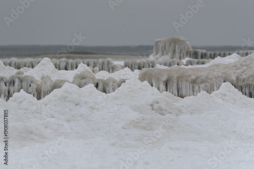FROSTY WINTER ON THE SEA COAST - Icy sea shore and wooden groynes potecting the shoreline