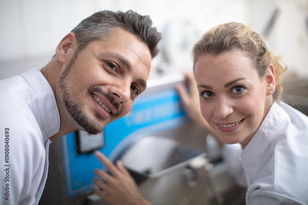 Fototapeta premium two smiling factory workers stood in a food factory