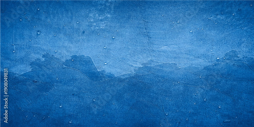 A dark and aged blue grunge concrete wall texture featuring a rough vintage paint surface and a dirty antique paper pattern design for a textured backdrop