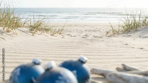 Wallpaper Mural christmas blue ornaments. A serene beach scene featuring blue ornaments resting on soft sand, with gentle waves in the distance and wispy grass framing the tranquil shoreline Torontodigital.ca