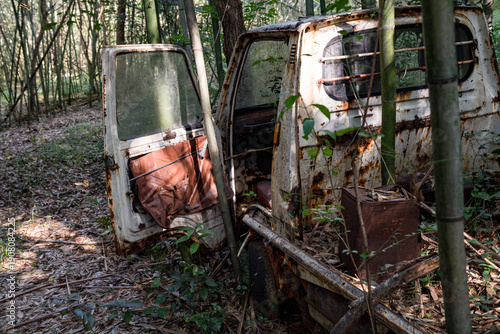 竹林に放置された錆びた軽トラックの廃車風景