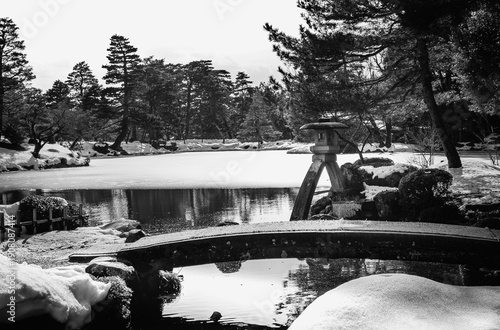 Photography Stone lantern, or Kotoji‑tōrō in Japanese, at the water’s edge of Kasumiga‑ike Pond in Kenroku‑en Park, Kanazawa, Ishikawa, Japan