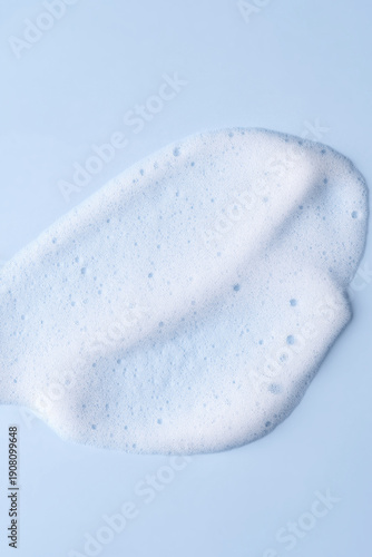 Skincare cleanser foam texture. Soap, shampoo, cleansing mousse bubbles swatch on blue color background. Face wash cosmetics