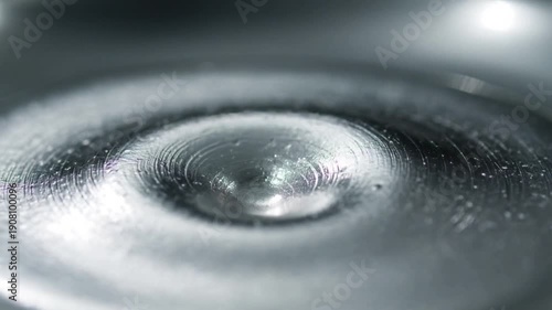 Starting from small disturbance, metallic dome rising, inverting in shallow pool with ripples