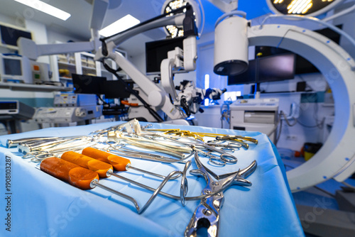 Professional neurosurgical tool set in operating room setting. Close-up of various stainless steel surgical retractors and clamps on a sterile table in a neurosurgery suite.
