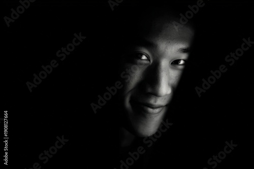 Mysterious glance of young asian male in low light setting