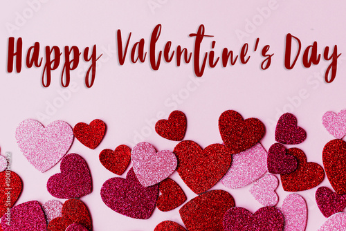 Happy valentines day greeting card. Happy Valentine's day text and pink and red glitter hearts flat lay on pink paper background. love banner.