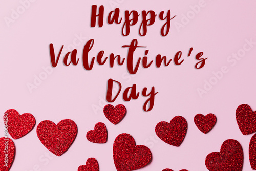 Happy valentines day greeting card. Happy Valentine's day text and stylish red glitter hearts flat lay on pink paper background.