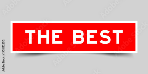 Red color square shape sticker label with word the best on gray background