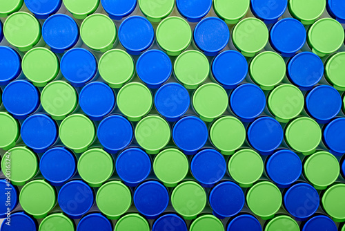 Large group of plastic bottles lined up on a table.