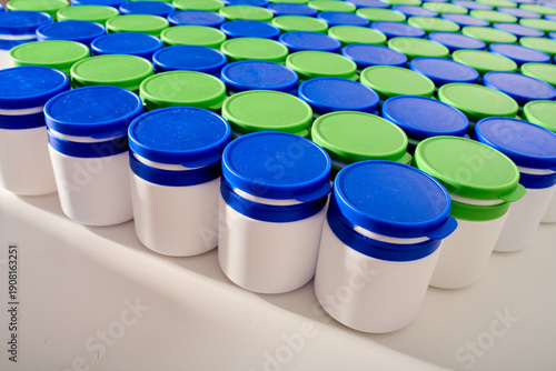 Large group of plastic bottles lined up on a table.